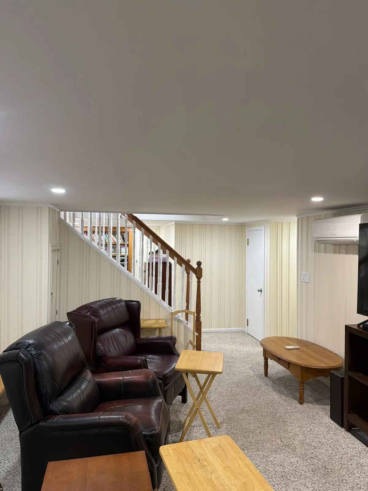 Finished basement lounge with staircase by Maitland Builders